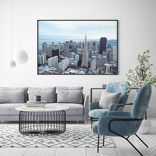 постер с городским пейзажем над диваном в современной гостиной