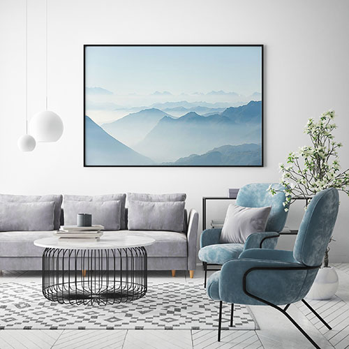 постер с горным пейзажем над диваном в современной гостиной
