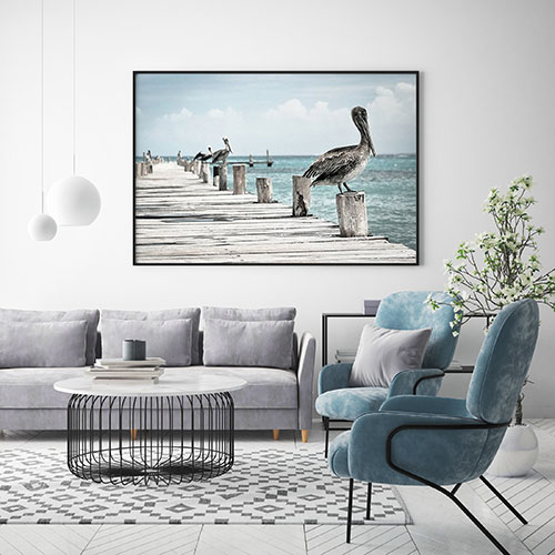 постер с пеликаном на пирсе над диваном в современной гостиной