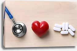 Постер Красное сердце с стетоскопом и таблетками на столе