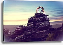 Постер Женщина делает гимнастику на скале
