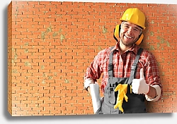 Постер Строитель в желтом шлеме у кирпичной стены