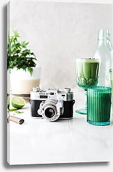 Постер Старый фотоаппарат на столе с зеленой посудой