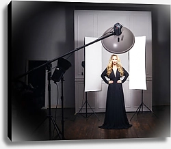 Постер Красивая модель позирует в черном платье в фотостудии