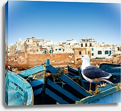 Постер Синие рыбацкие лодки и чайка на берегу океана в Эс-Сувейра, Марокко