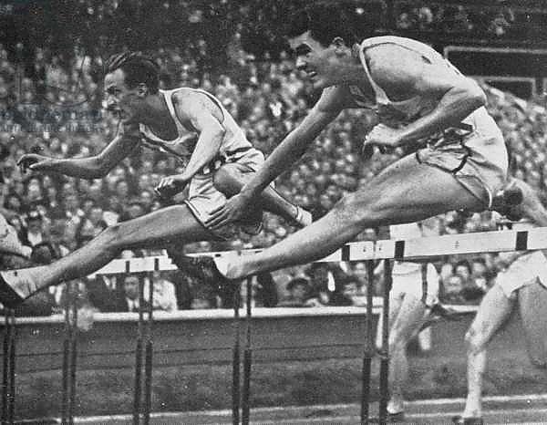 William Porter on his way to winning Gold in the 110 m. hurdles event with a new Olympic record time of 13.9 secs. at the 1948 London Olympic Games