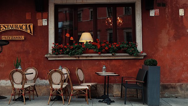 Столики уличного кафе у красной стены