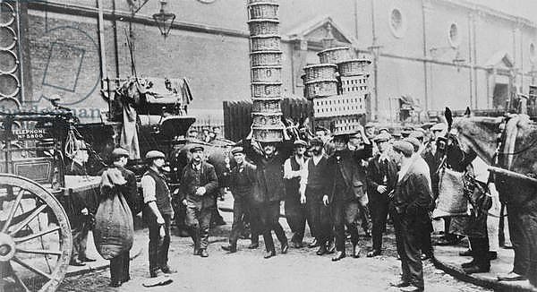 View of expert basket carriers and a group of market men, 1900