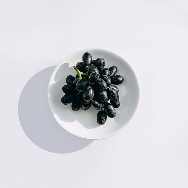 Черный виноград в круглой тарелке