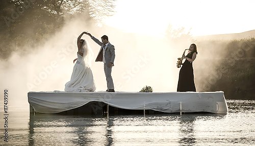 Невеста и жених танцуют на озере под живую музыку