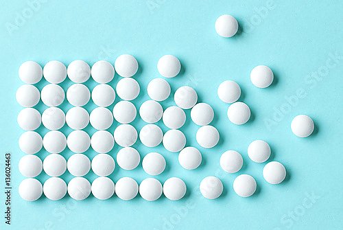 Белые таблетки на голубом фоне