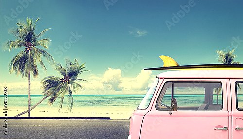 Винтажный автомобиль на пляже с доской для серфинга на крыше