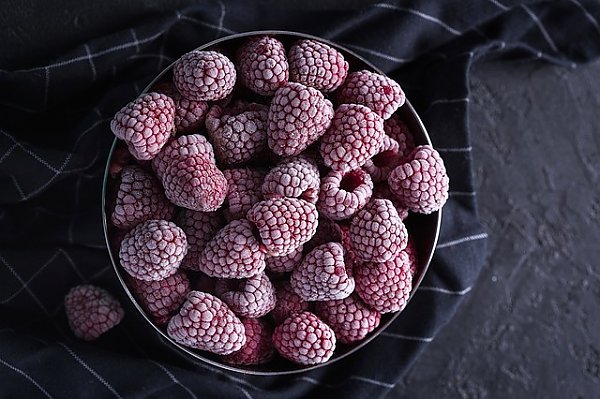 Замороженные ягоды малины в черной миске