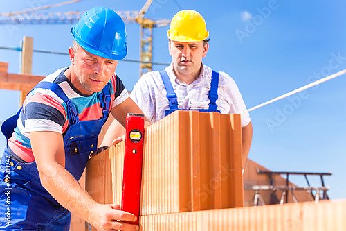 Рабочие на строительстве кирпичного здания