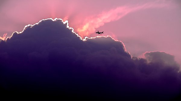 Самолет над розовыми облаками