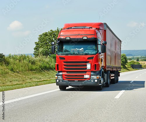 Красный грузовик с трейлером на шоссе