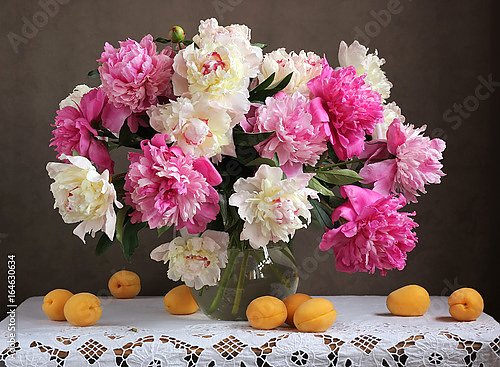 Цветы в вазе и абрикосы на столе