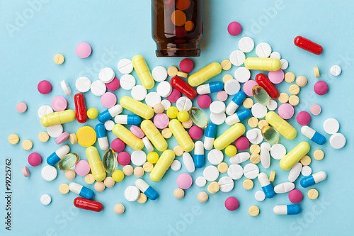 Рассыпанные цветные таблетки на сголубом фоне