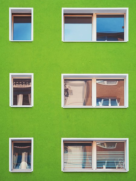 Стена зеленого дома с окнами