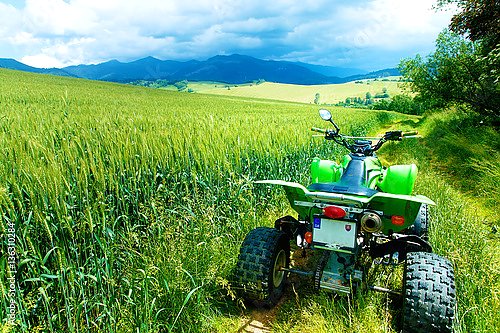 Зелёный квадроцикл в летнем поле