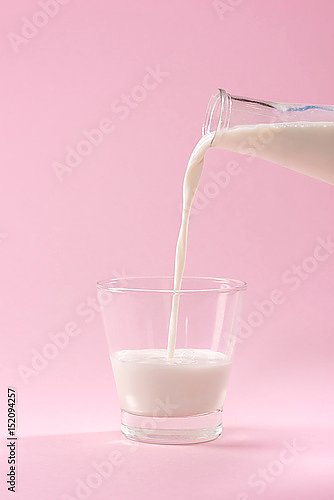 Стакан молока на розовом фоне
