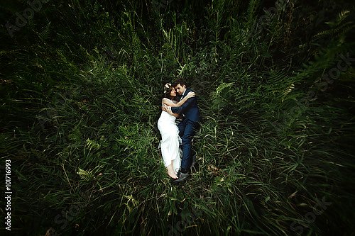 Счастливая невеста и стильный жених, лежащие на траве