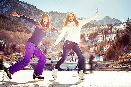 Две девушки на коньках на открытом воздухе