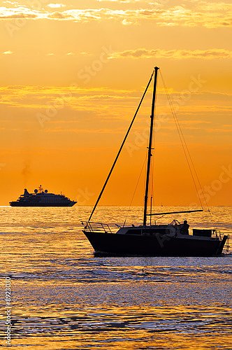 Лодка и яхта на фоне оранжевого заката
