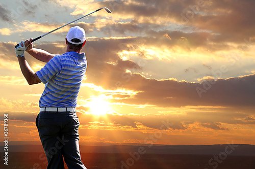 Мужчина играющий в гольф на фоне заката