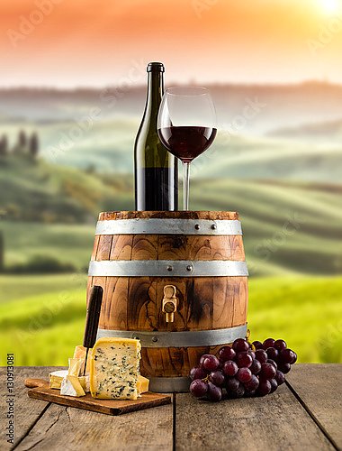 Красное вино на деревянной бочке, на фоне виноградника
