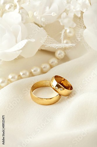 Обручальные кольца на белом кружеве с жемчужным ожерельем