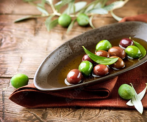 Зеленые и зрелые оливки в чаше на столе