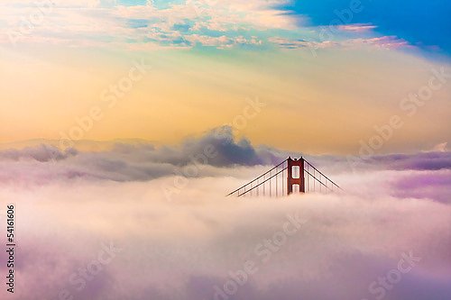 Всемирно известный мост Золотые Ворота в густом тумане после восхода солнца