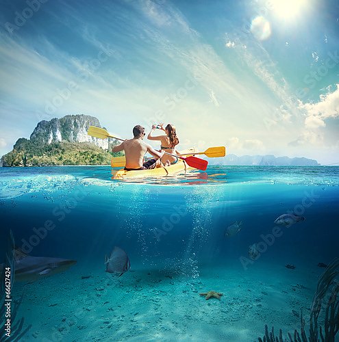 Молодая пара на каяке у тропического острова