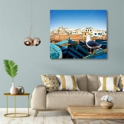 «Синие рыбацкие лодки и чайка на берегу океана в Эс-Сувейра, Марокко» в интерьере современной гостиной с голубыми стенами