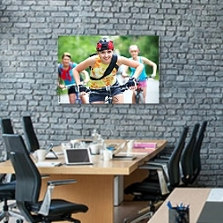 «Три девушки-велосипедистки» в интерьере современного офиса с черной кирпичной стеной