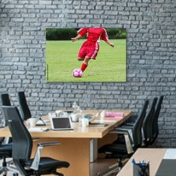 «Футболист в красной форме с мячом» в интерьере современного офиса с черной кирпичной стеной