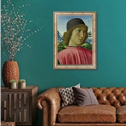 «Портрет молодого человека в красном» в интерьере гостиной с зеленой стеной над диваном