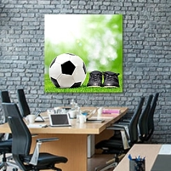 «Футбольный мяч и бутсы на зеленой траве» в интерьере современного офиса с черной кирпичной стеной