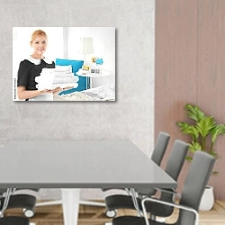 «Красивая домработница держит стопку чистых полотенец» в интерьере современного офиса над столом для конференций