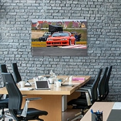 «Красный гоночный автомобиль на трассе» в интерьере современного офиса с черной кирпичной стеной