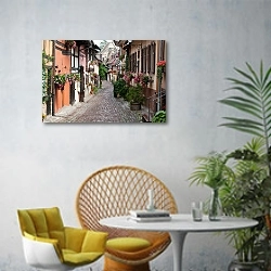 «Франция, Эльзас. Узкая улица с цветами в Эгишеме» в интерьере современной гостиной с желтым креслом