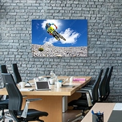 «Прыжок на горном велосипеде над склоном горы» в интерьере современного офиса с черной кирпичной стеной