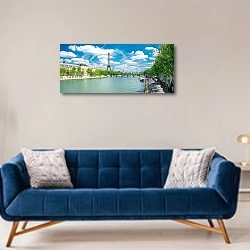 «Франция, Париж. Панорама Сены с облачным небом» в интерьере современной гостиной с синим диваном