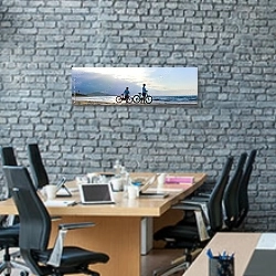 «Два велосипедиста на пляже» в интерьере современного офиса с черной кирпичной стеной