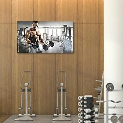 «Мускулистый мужчина в тренажерном зале с гантелями» в интерьере фитнес-зала с деревянной отделкой