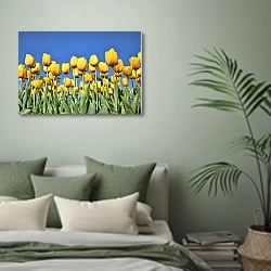 «Поле желтых тюльпанов на голубом небе» в интерьере современной спальни в зеленых тонах