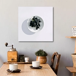«Черный виноград в круглой тарелке» в интерьере кухни над обеденным столом с кофемолкой