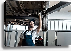 Постер Механик под небом автомобилей