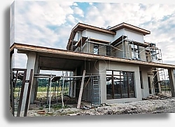 Постер building construction with scaffolding under cloudy sky
